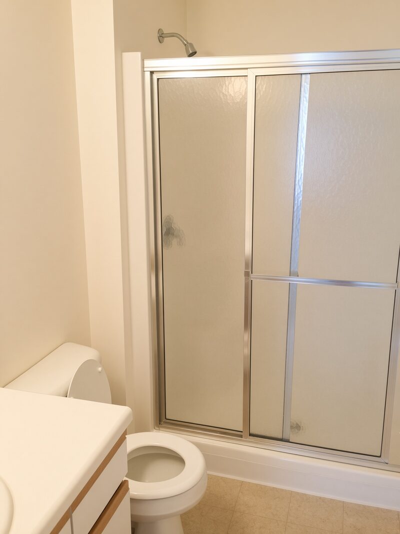 Bathroom wall and trim beside a shower enclosure.