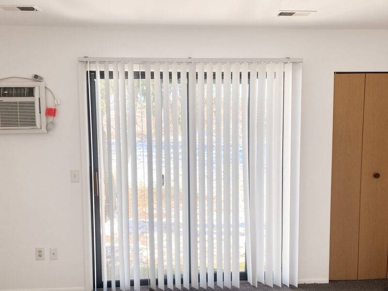 Vertical blinds across a sliding door with the surrounding wall painted.