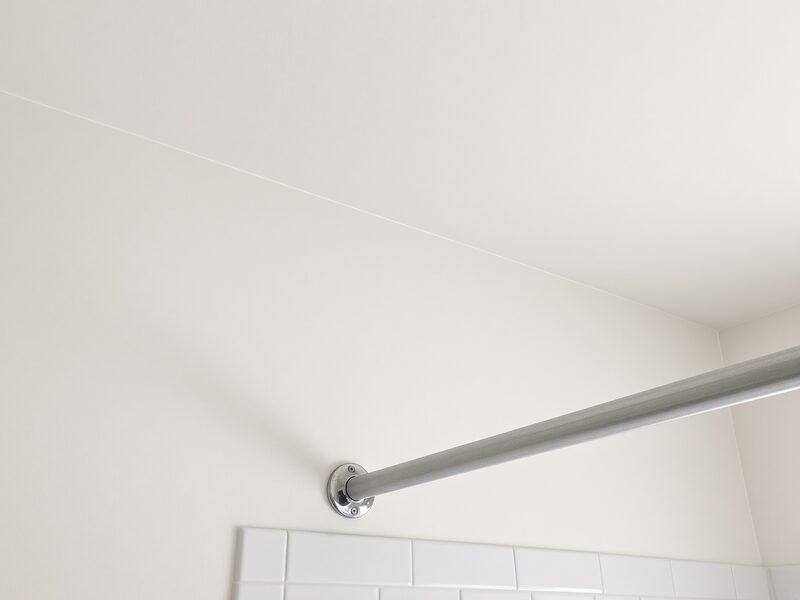 Shower curtain rod fixed to a finished wall above the tile.