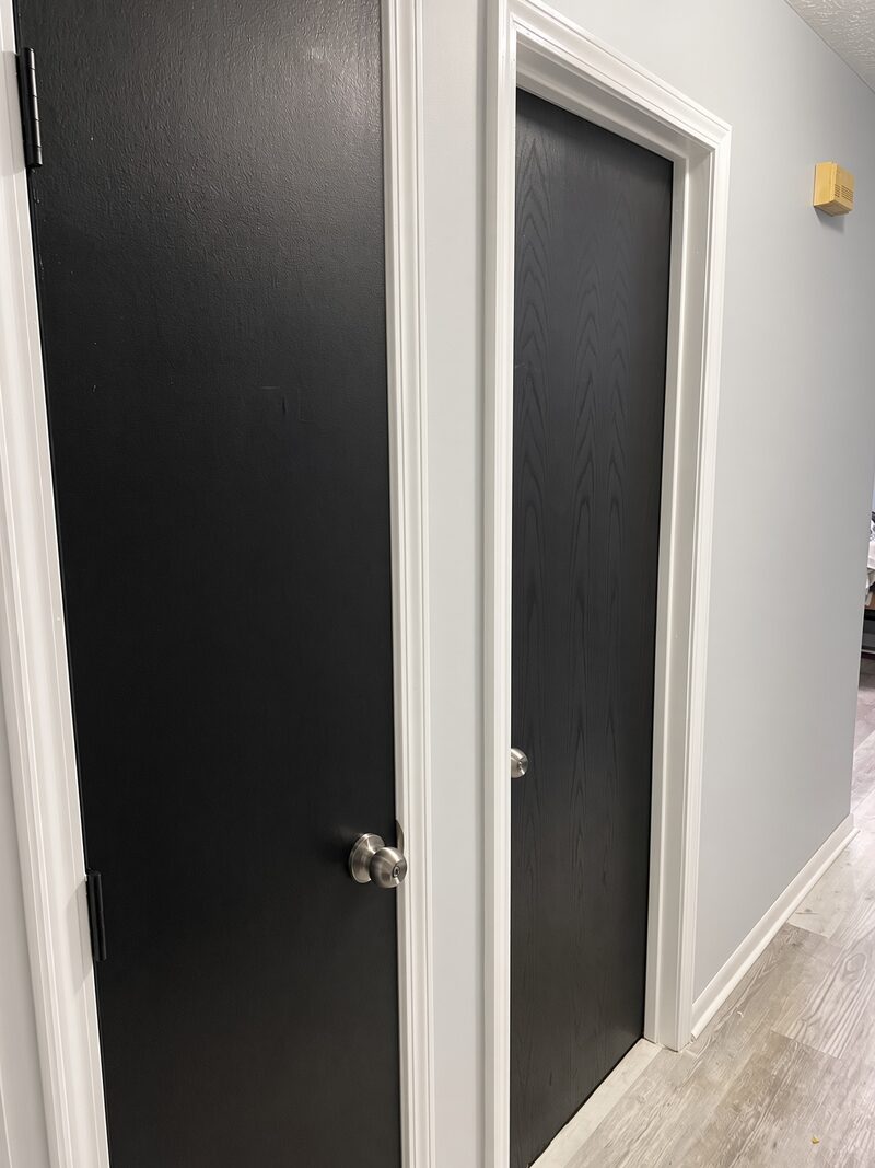 Charcoal door and closet door hung against white walls and trim.
